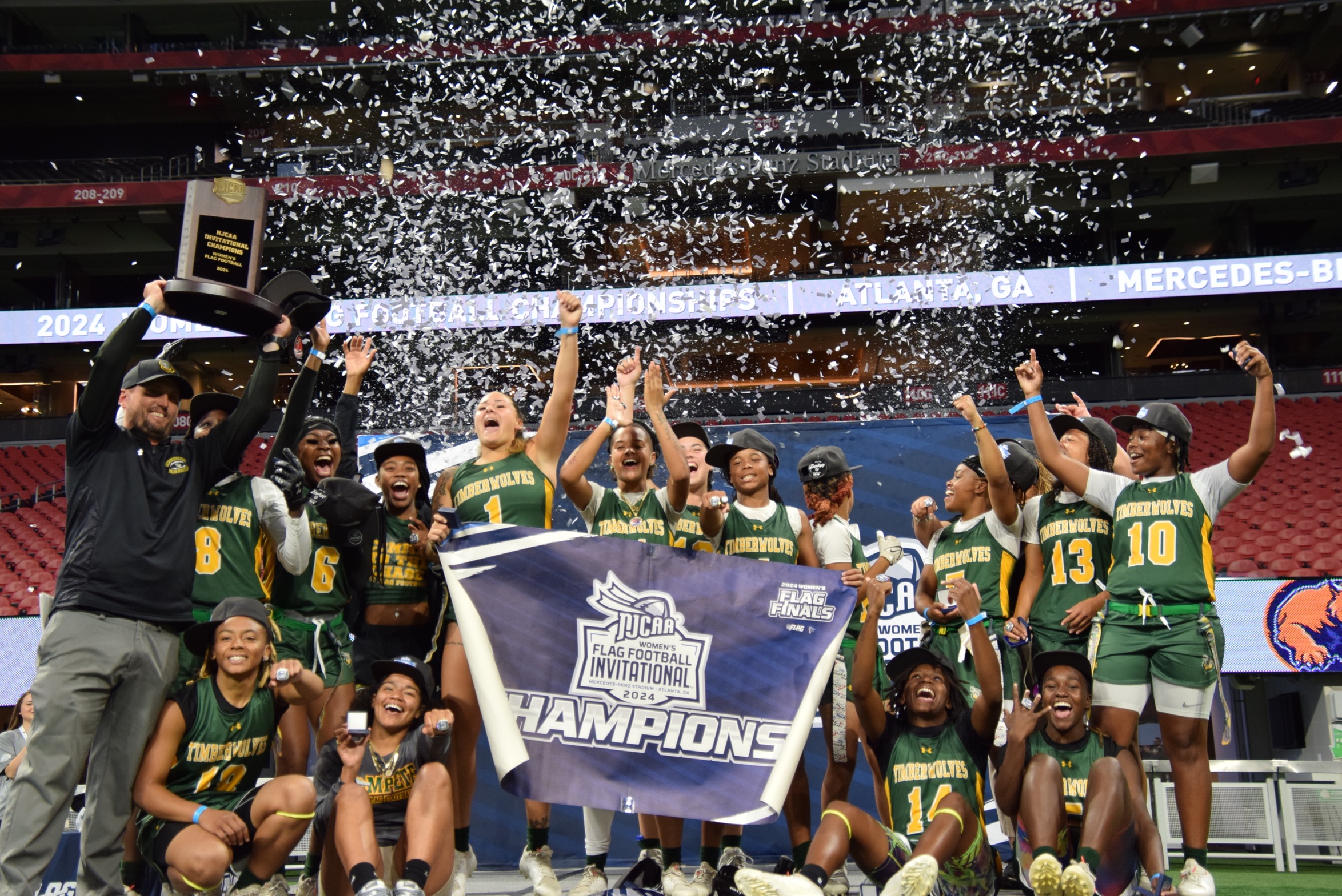 2024 FGC Women's Flag Football Team raising Championship Trophy, confetti in the air