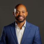 Headshot on man in white shirt and blue jacket