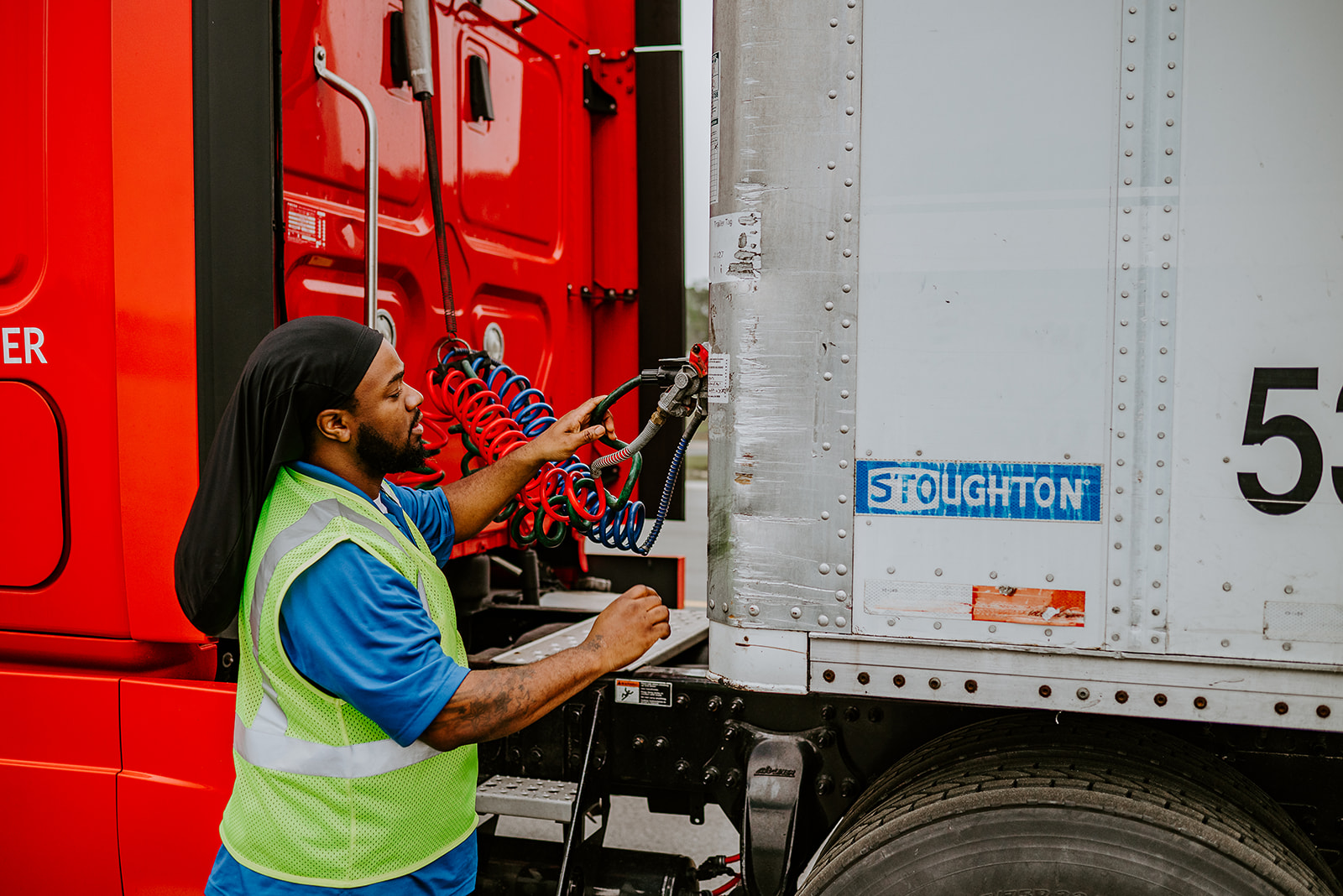 A CDL student inspects tractor trailer connection.