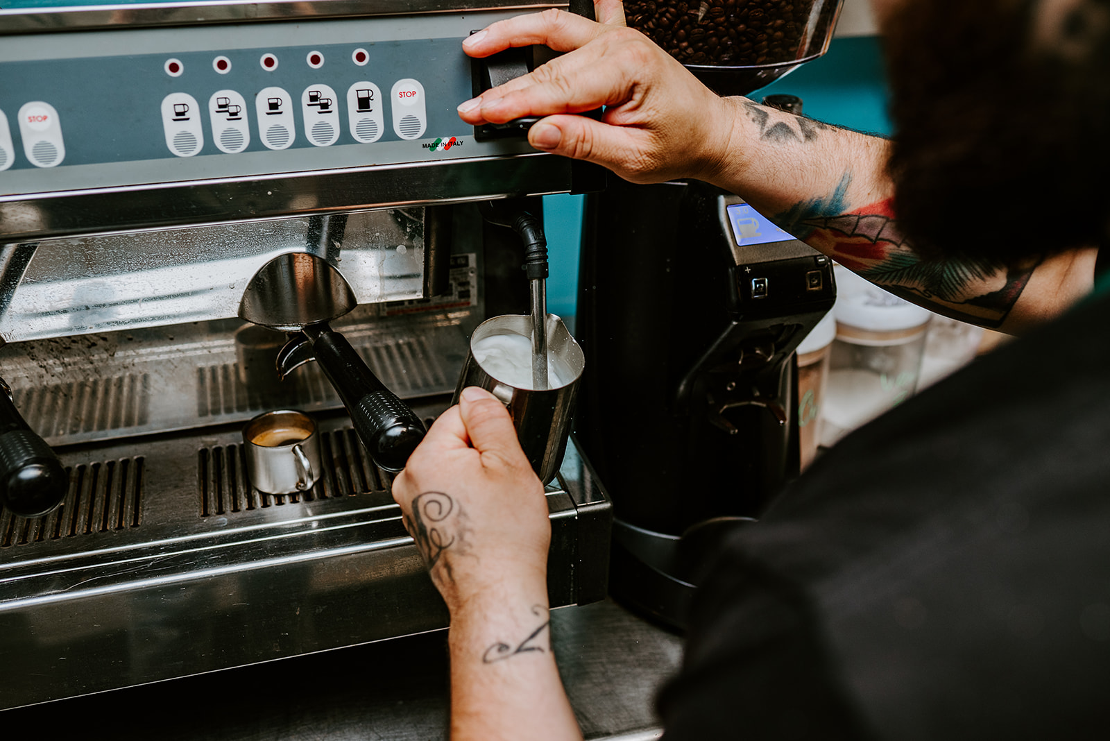 Barista steaming milk on espresso machine