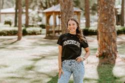 Student with FGC shirt standing outside on campus