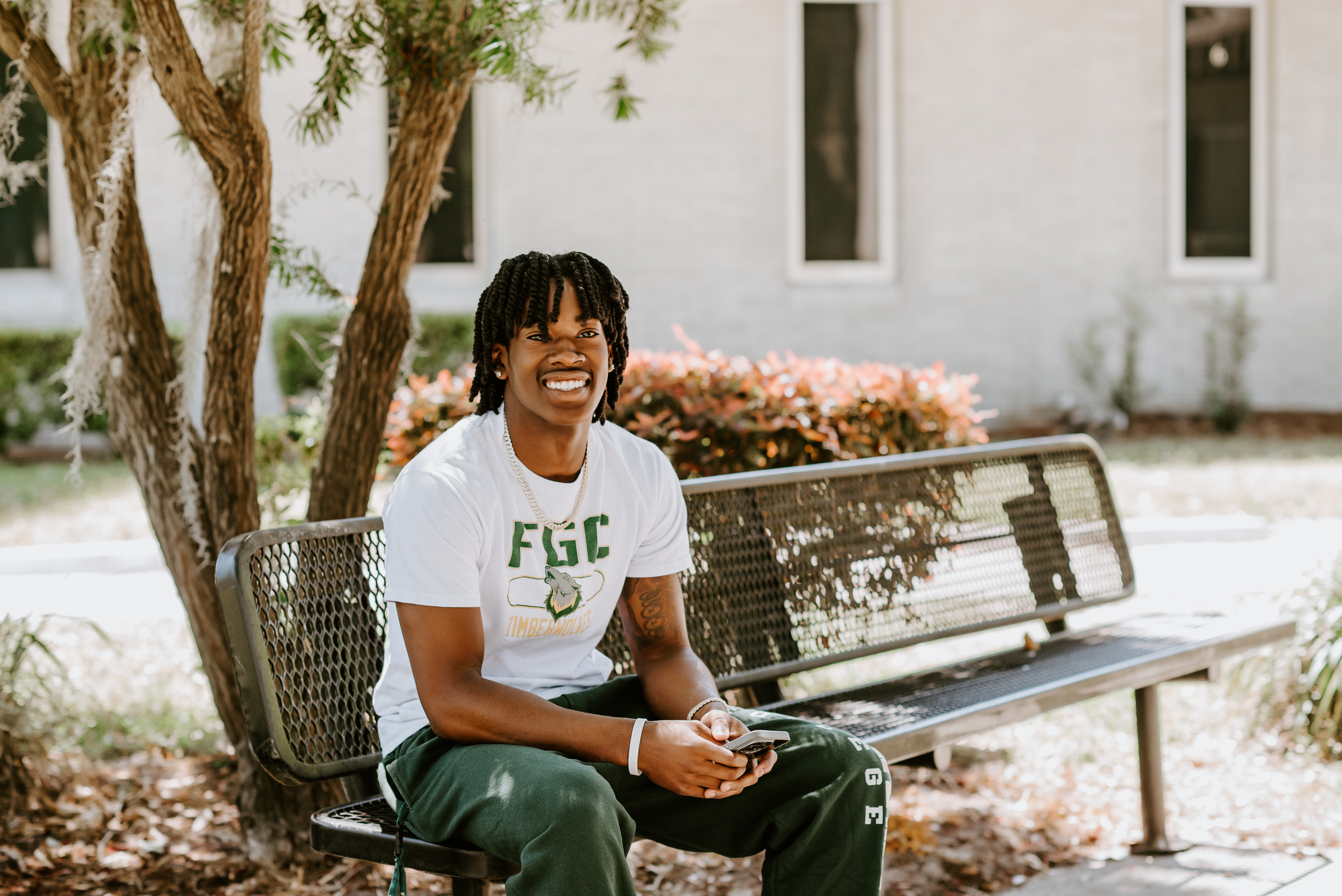 Student on outdoor bench smiling