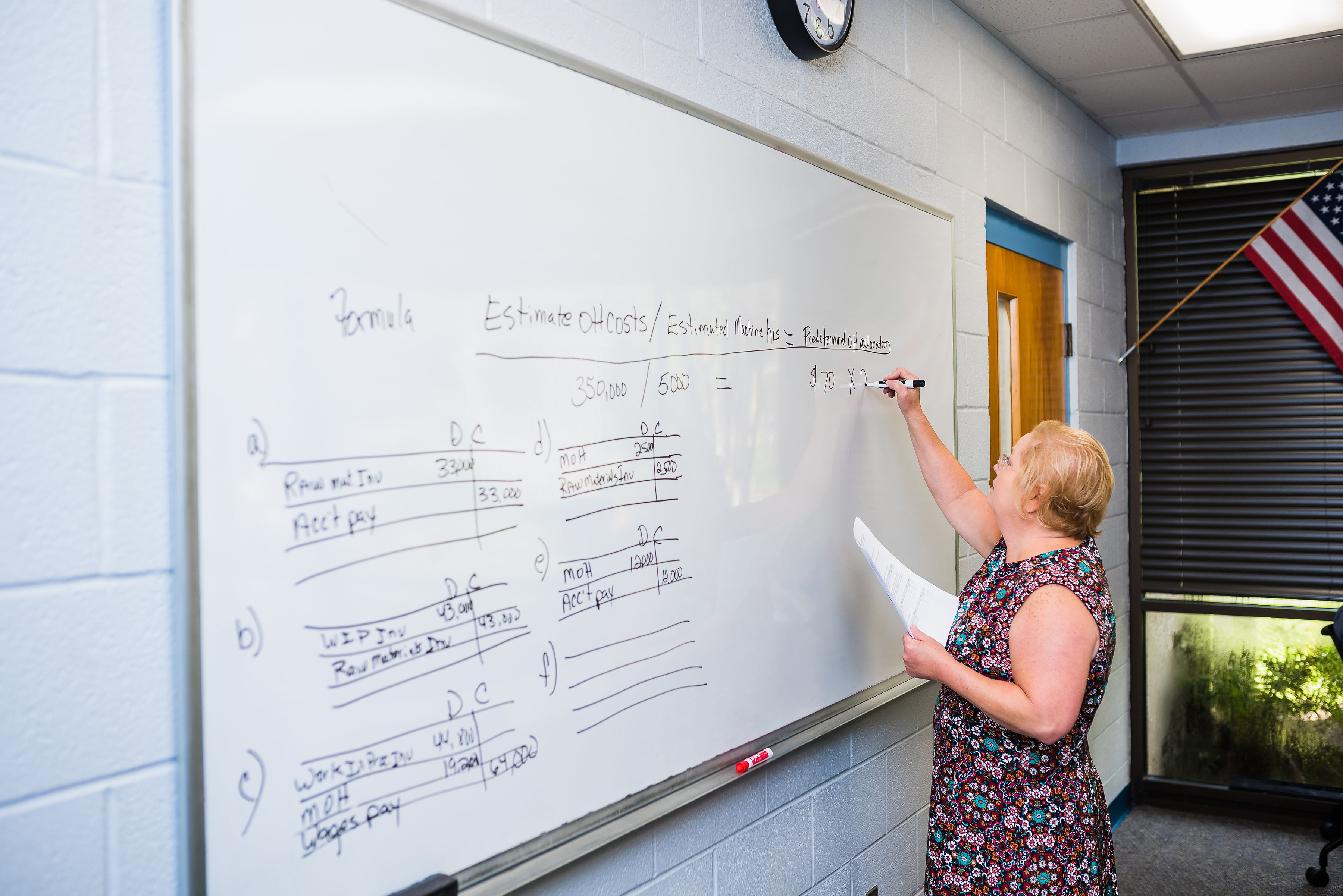 Accounting professor using whiteboard in classroom