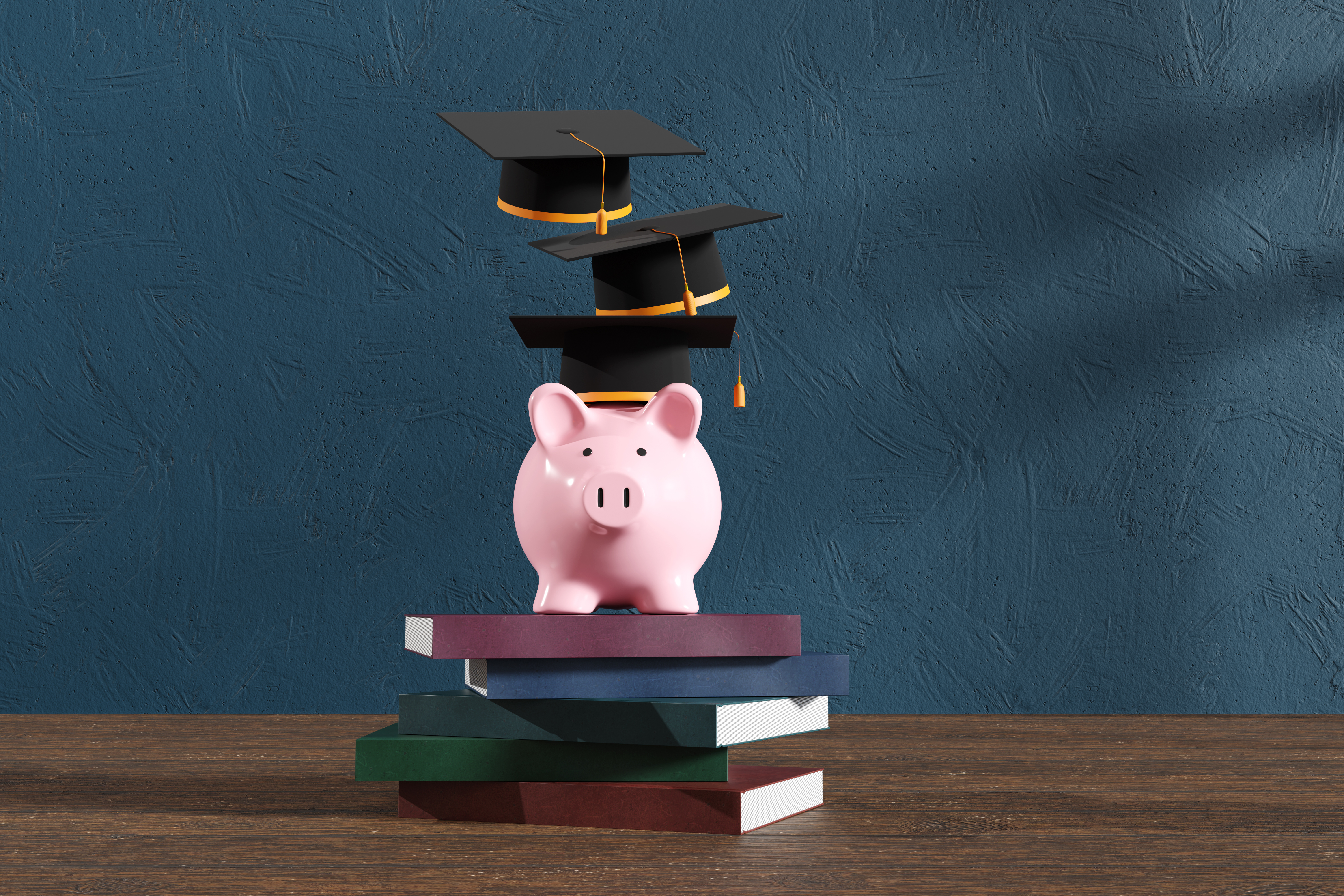 Set of books with a piggy bank and graduation caps on top