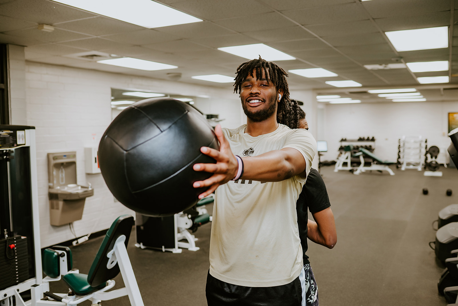 Male student holding medicine ball
