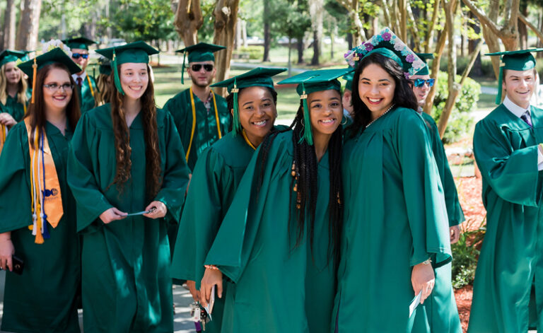 Graduates hugging outside and smiling