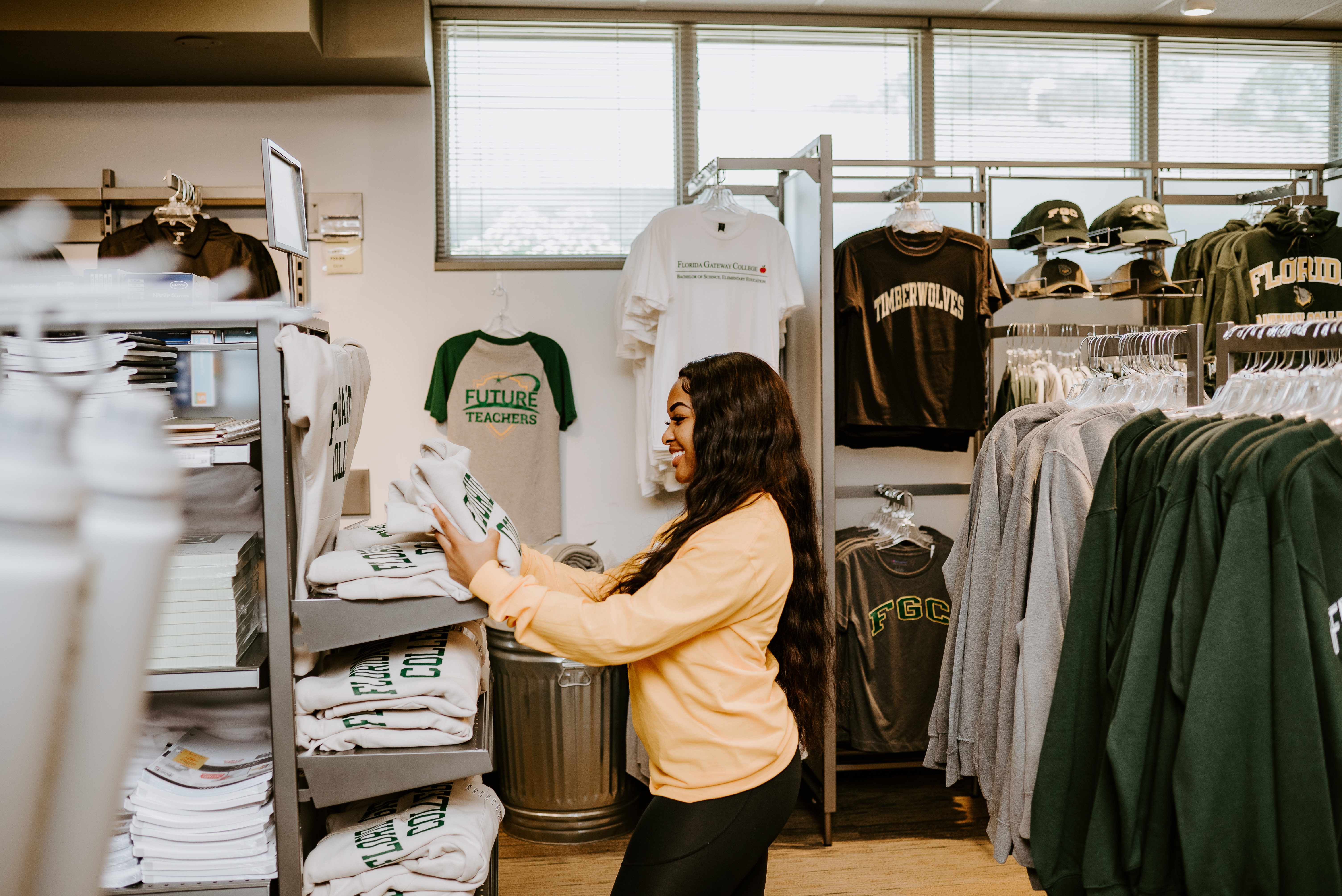 Student picking up a shirt in the Bookstore