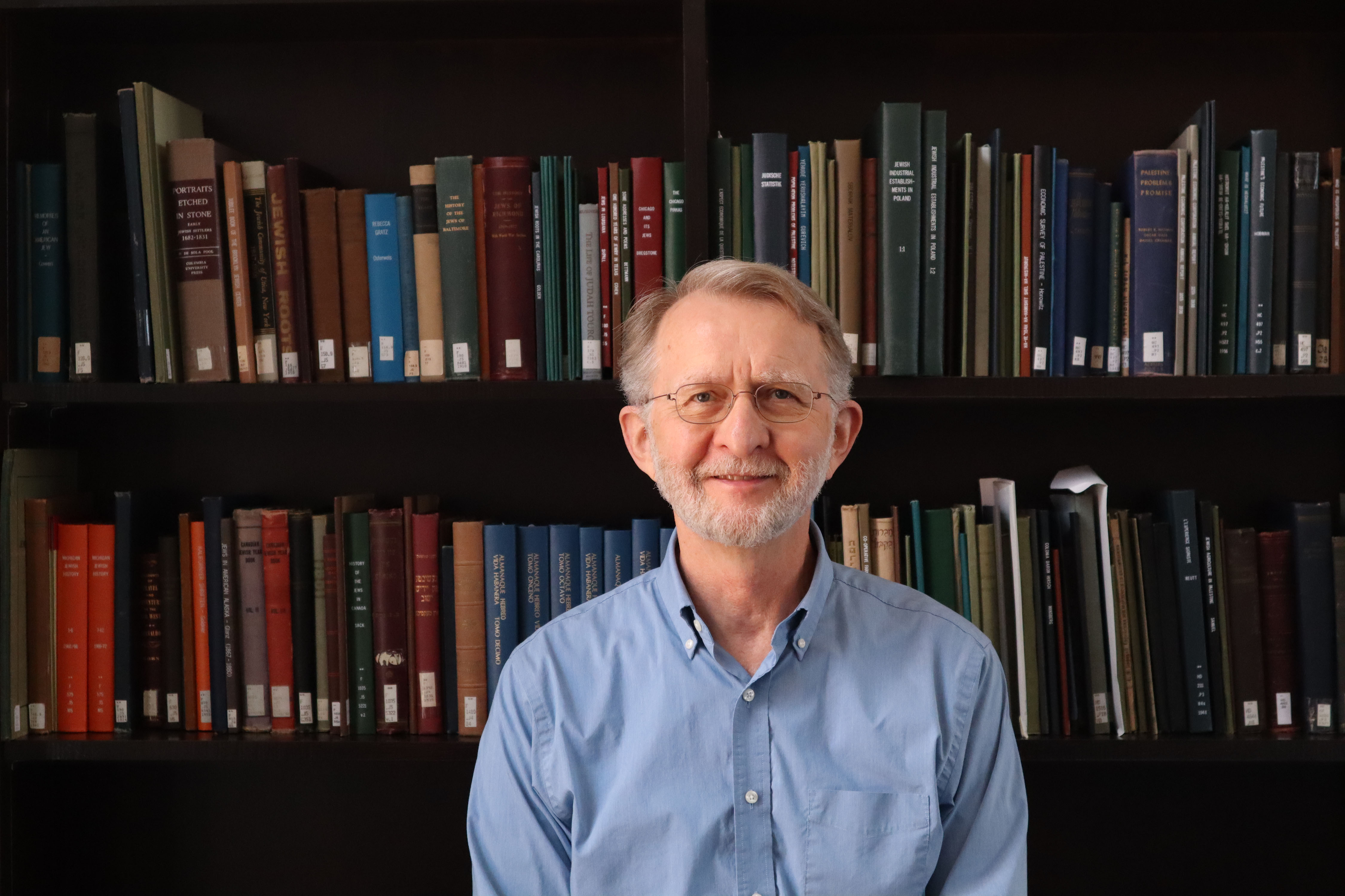 Man in front of library bookshelves